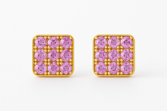 Square gold stud earrings featuring a grid of vivid pink sapphires set in a rounded-edge frame, with delicate gold bead prongs accentuating each stone. Displayed on a soft cream background with a subtle reflection.







