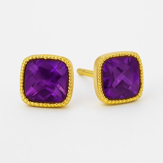 Cushion-cut amethyst stud earrings set in a square gold bezel with delicate beaded detailing along the border, displayed on a soft cream background with a gentle reflection.