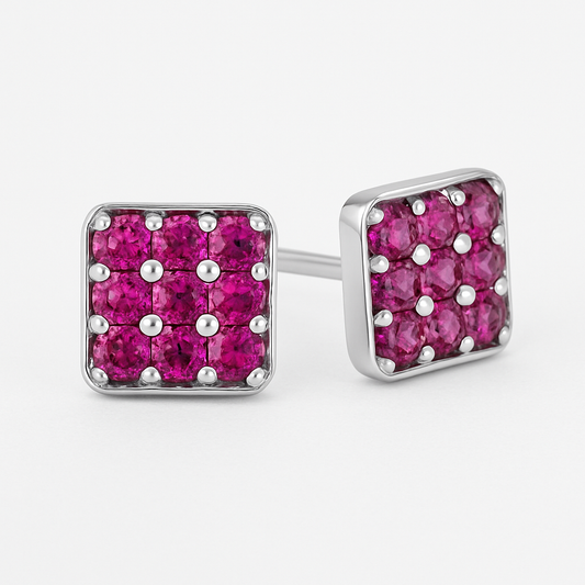 Square gold stud earrings featuring a grid of vivid pink sapphires set in a rounded-edge frame, with delicate gold bead prongs accentuating each stone. Displayed on a soft cream background with a subtle reflection.