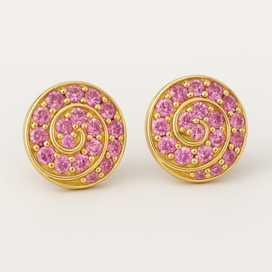A pair of round gold stud earrings featuring a spiral design set with vibrant pink sapphires. Each earring showcases 14 gemstones intricately arranged along a golden swirl pattern, displayed against a soft cream background.